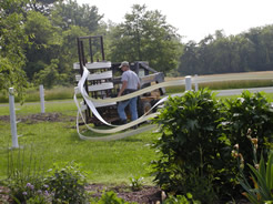 Using a skidloader to roll out flexible rail horse fence materials